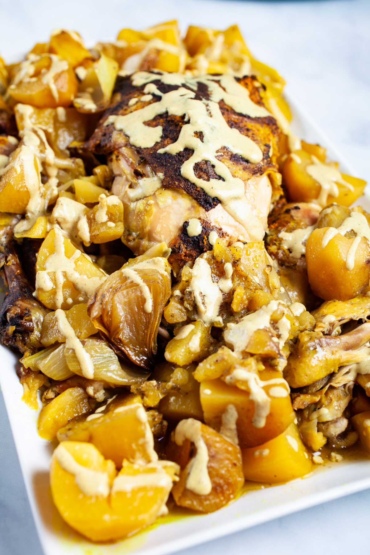 A beautiful dish with a whole chicken and potatoes topped with a healthy gravy.