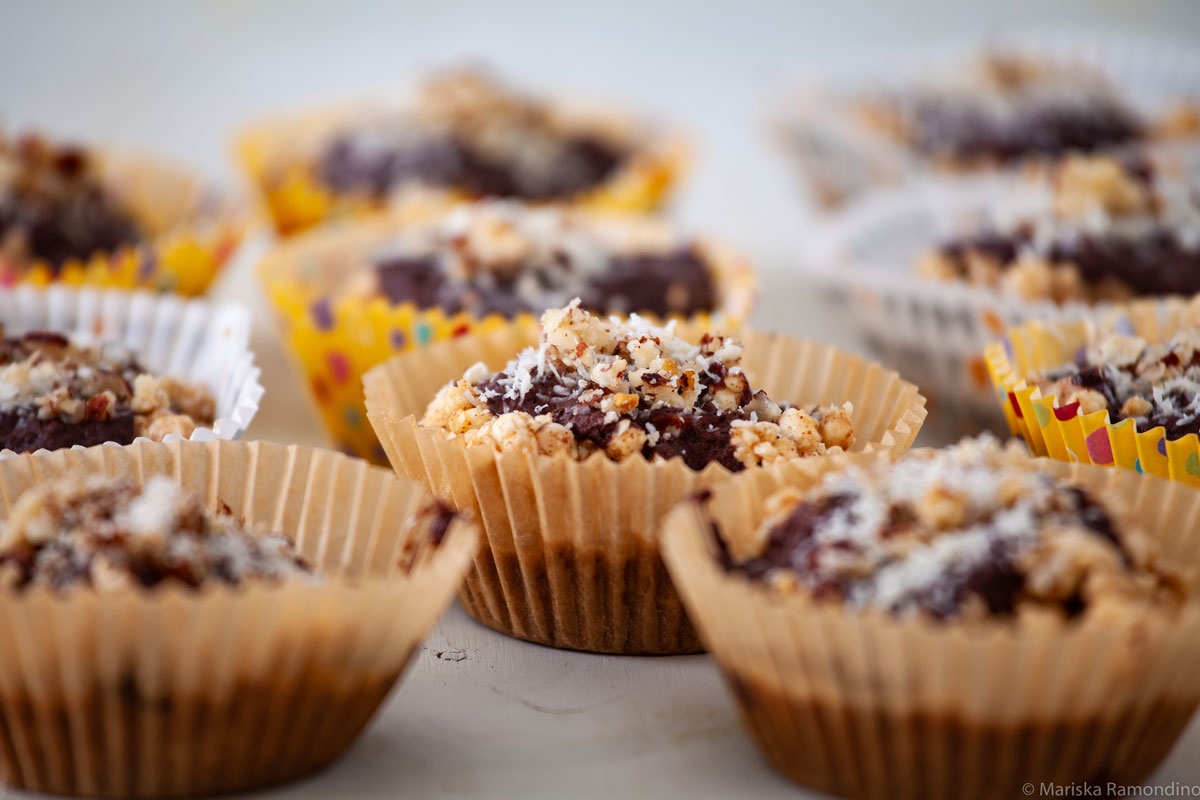 several individual chocolate rice crispy treats in cupcake liners on a table.