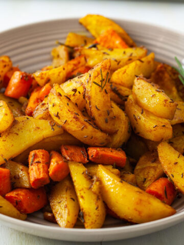 Oven-baked Potatoes with Jamaican Curry and Caraway Fruits with Rosemary for Garnish