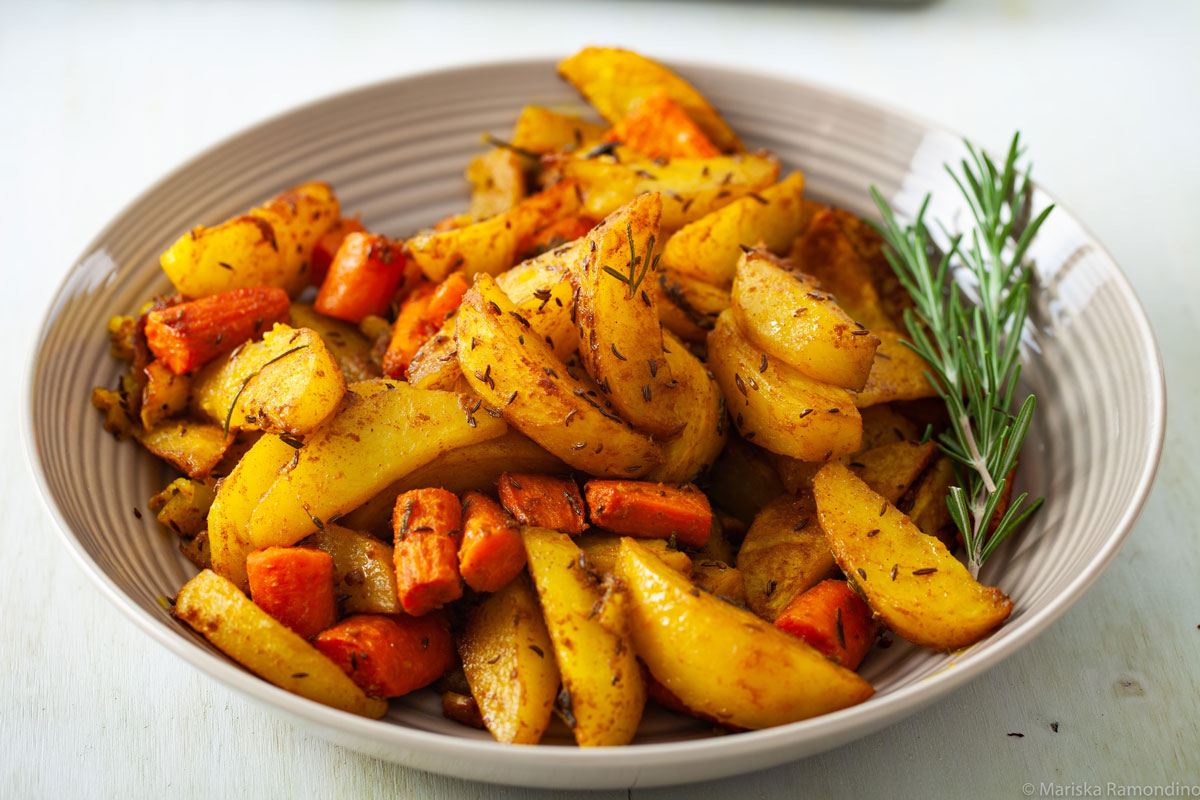 Oven-baked Potatoes with Jamaican Curry and Caraway Fruits with Rosemary for Garnish