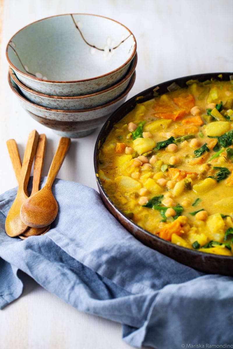 ONE HEARTY VEGETABLE STEW RECIPE WITH BOWLS AND WOODEN SPOONS