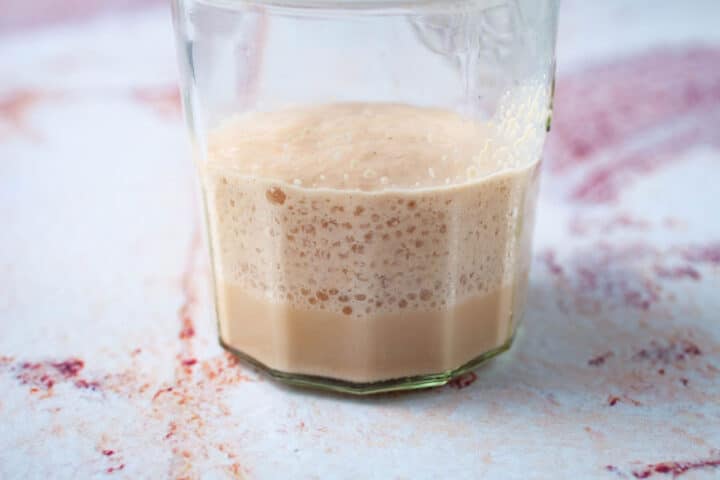 Leavened and activated yeast in a glass cup.