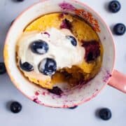 A bite taken out of an almond flour mug cake with blueberries.