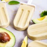 Creamy avocado popsicles on a table.