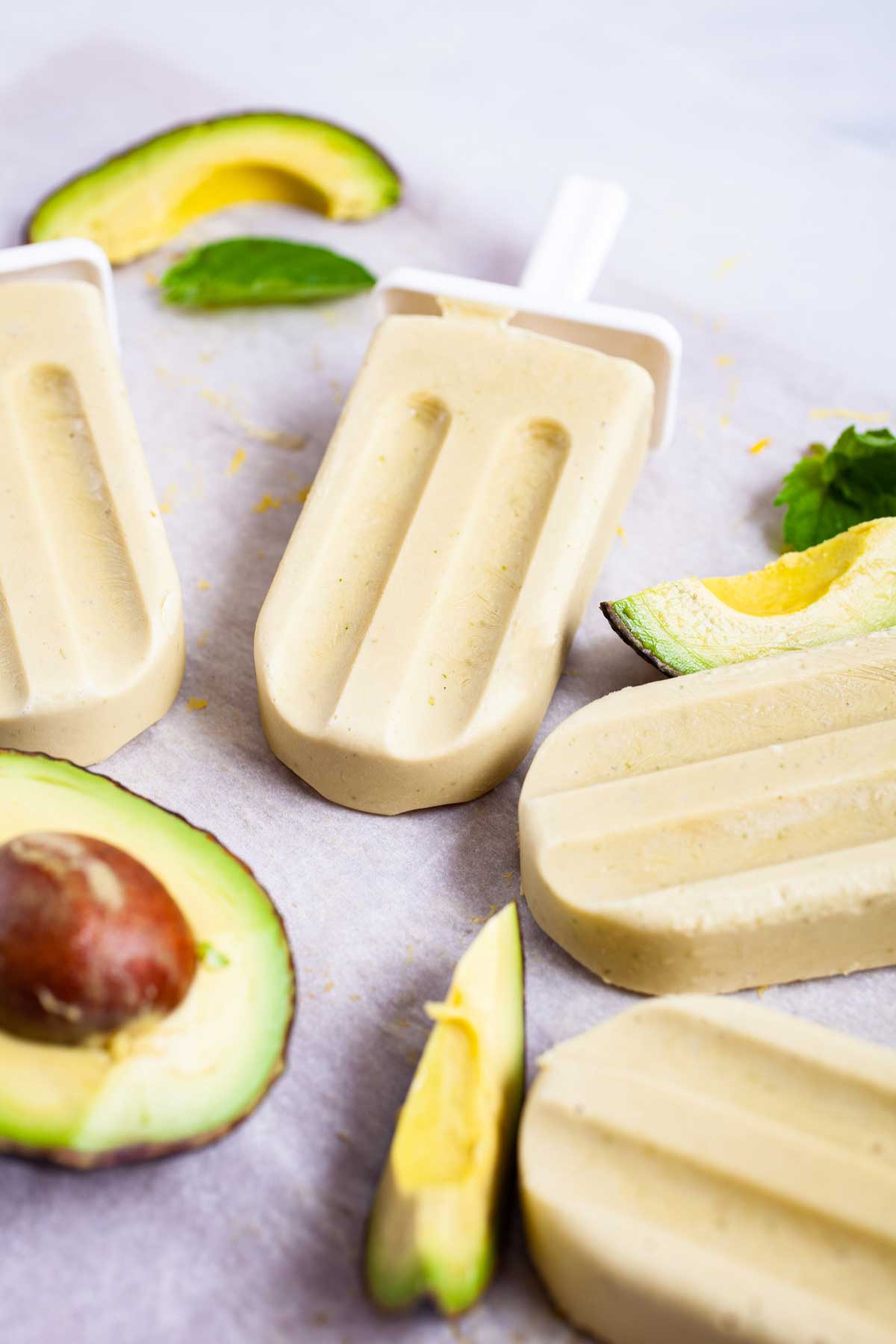 Creamy avocado popsicles on a table.