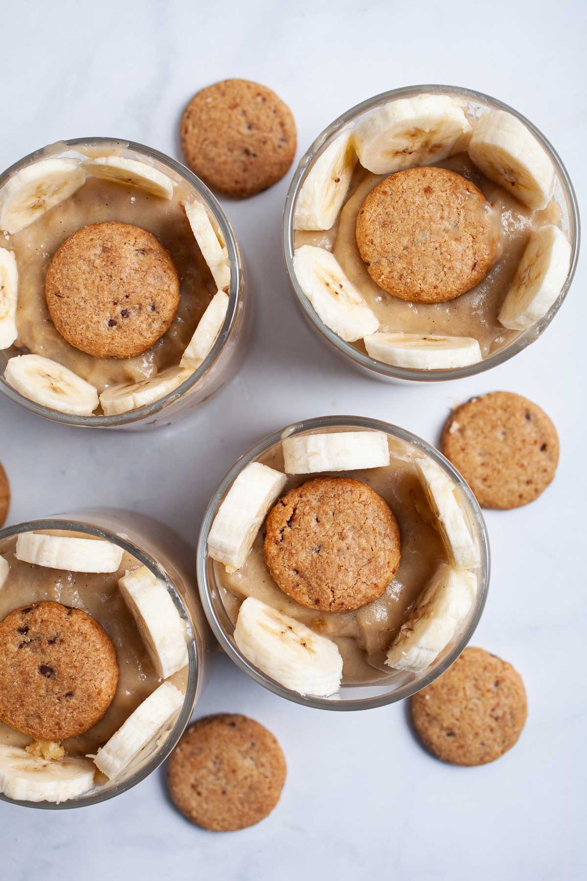 Cups of creamy Paleo banana pudding garnished with cookies.