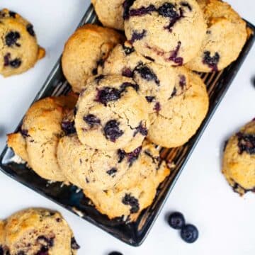 Olive oil cookies with lemon and blueberries beautifully displayed on a table.