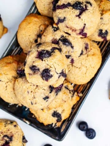 Olive oil cookies with lemon and blueberries beautifully displayed on a table.