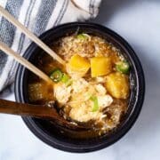 Chopsticks and a wooden spoon in a bone broth breakfast bowl.