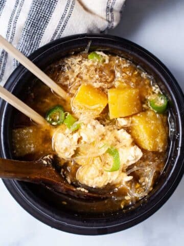 Chopsticks and a wooden spoon in a bone broth breakfast bowl.