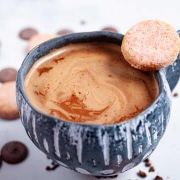 Bone broth hot chocolate in a cup surrounded by cookies and chocolate wafers.
