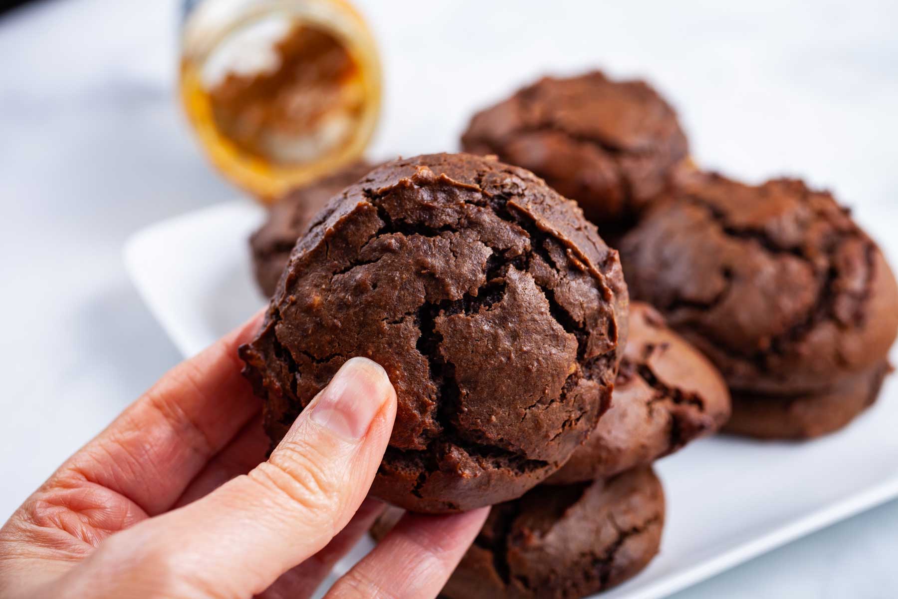 A hand holding up a brownie peanut butter cookie.