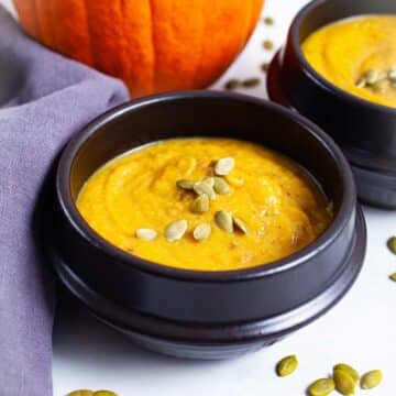 Creamy cauliflower pumpkin soup served in bowls.