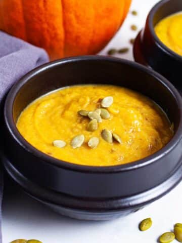 Creamy cauliflower pumpkin soup served in bowls.