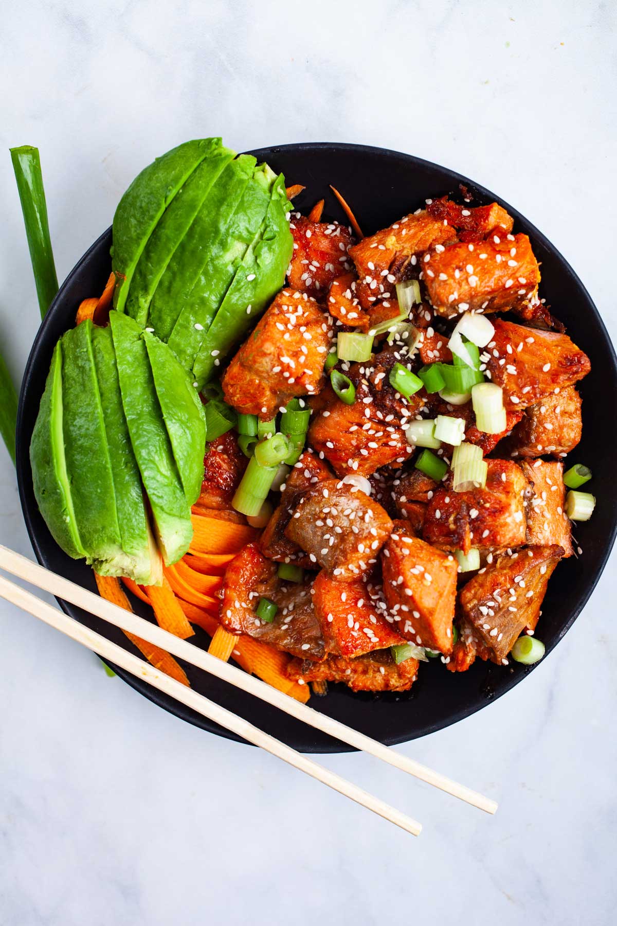 Salmon Bites served with avocado and veggies in a bowl.