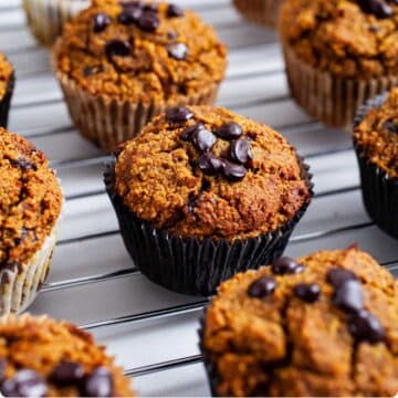 Chocolate chip date pumpkin muffins on a cooling rack.
