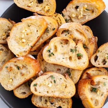 Oven-roasted garlic crostini toasts topped with garlic and fresh herbs.