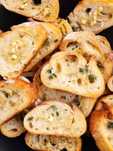 Oven-roasted garlic crostini toasts topped with garlic and fresh herbs.