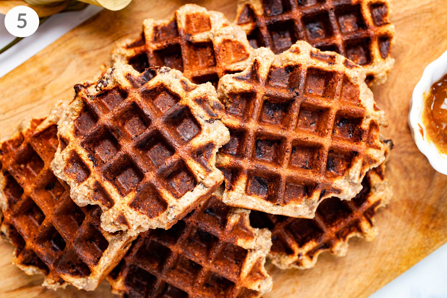 Golden brown oat flour waffles on a board.