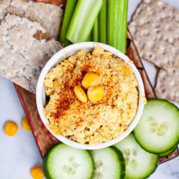 Keto hummus with lupini beans surrounded with fresh veggies and crackers.