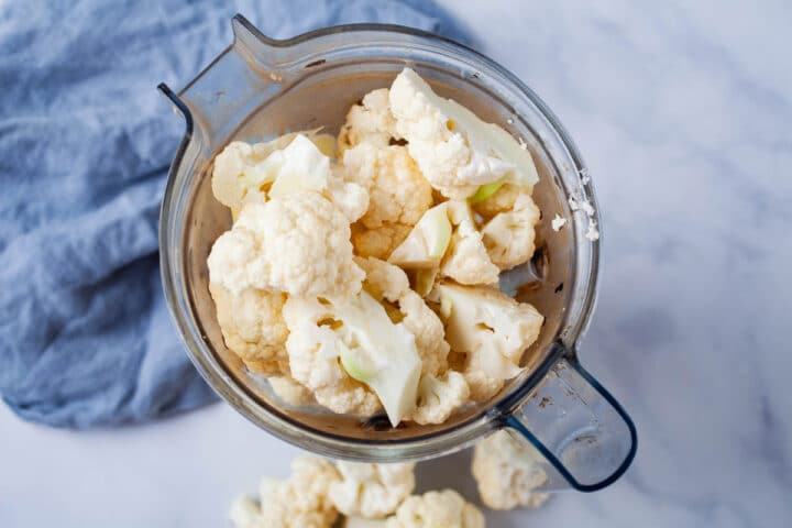 Chopped cauliflower florets in a Vitamix blender.