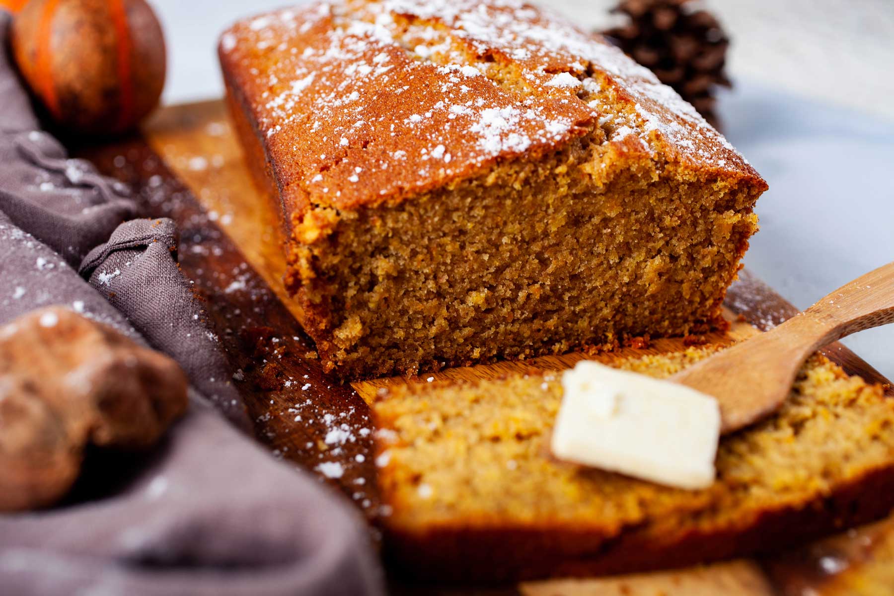 A sliced spelt cake loaf topped with butter.