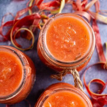 Strawberry rhubarb sauce in glass jars.