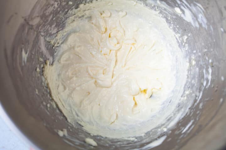A stainless steel bowl with blended cream cheese.