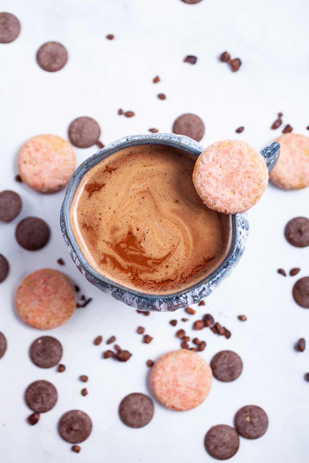 Bone broth hot chocolate in a cup surrounded by cookies and chocolate wafers.