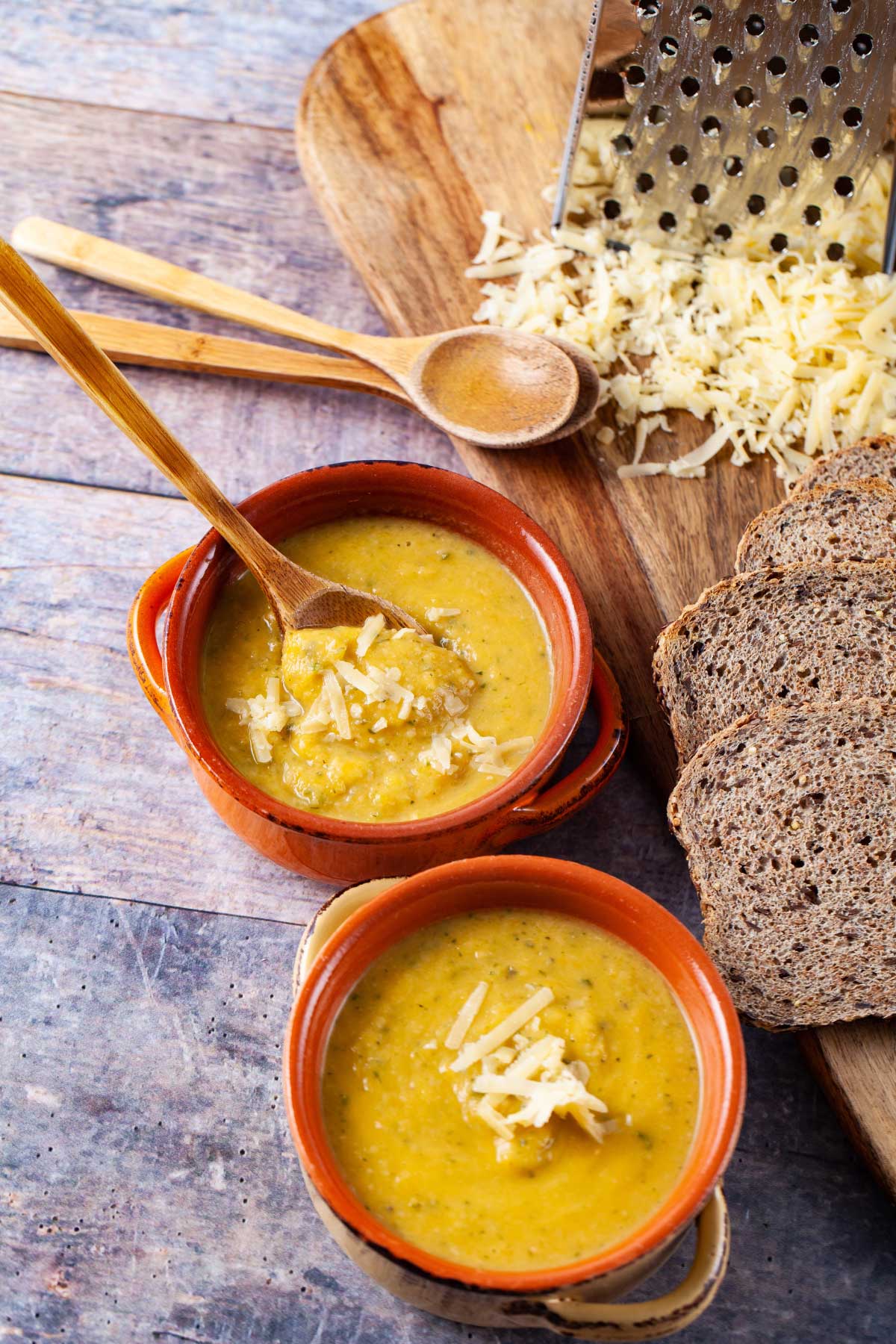 Bowls of butternut squash soup topped with Parmesan cheese.