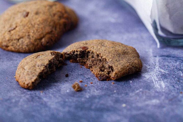 A close up of a chocolate chip cookie broken in two.