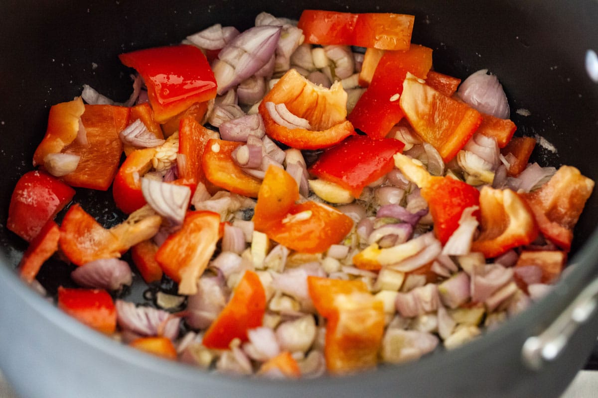 Chopped challot and red bell pepper in a large pot.
