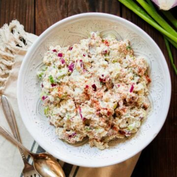 Shredded cauliflower salad with a creamy dressing served on a plate.