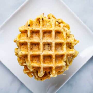 A stack of cheese waffles on a plate.