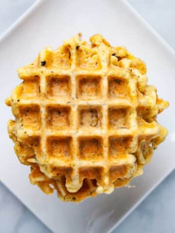 A stack of cheese waffles on a plate.