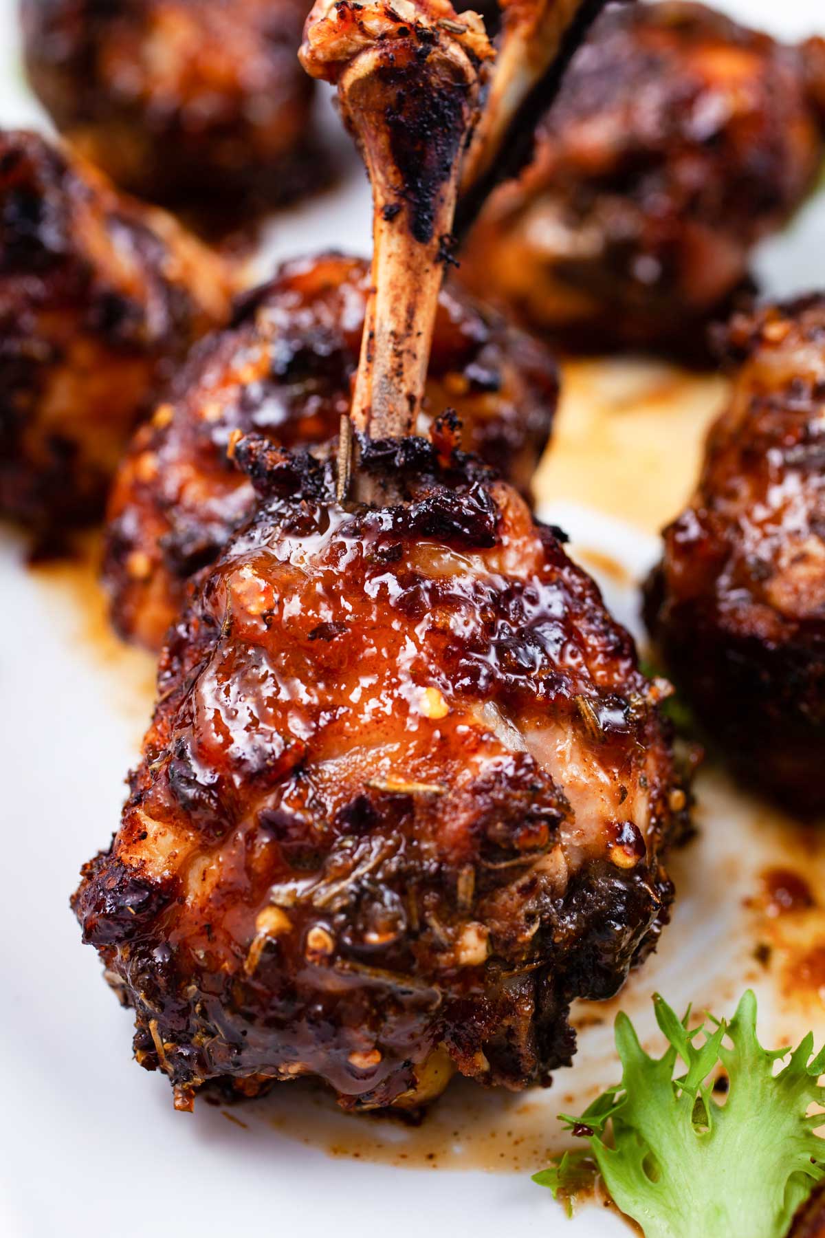 Oven baked lollipop drumsticks on a serving plate.