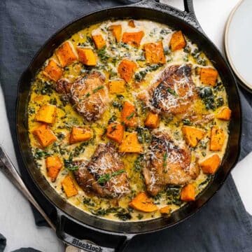 Baked chicken with sweet potatoes in a curry sauce served in a one-pan skillet.