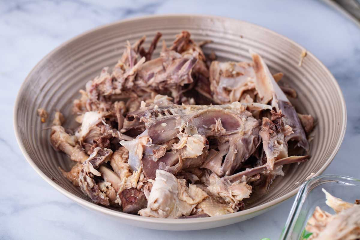 A large plate filled with chicken bones, scraps, and fat.