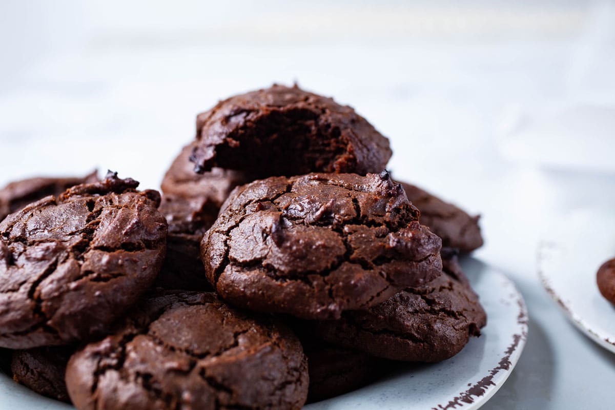 Soft brown chocolatey peanut butter cookies stacked on a small plate.