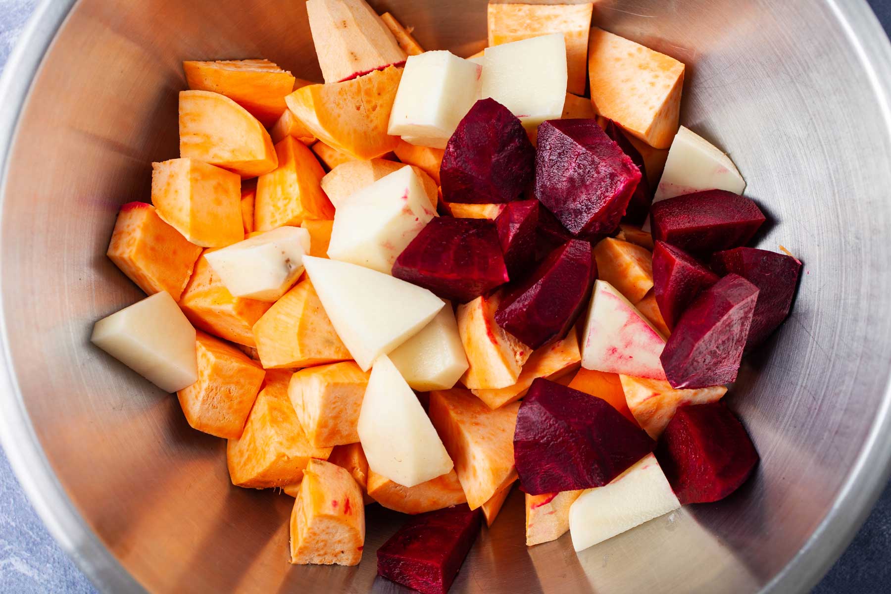 Chopped raw root vegetables in a bowl.
