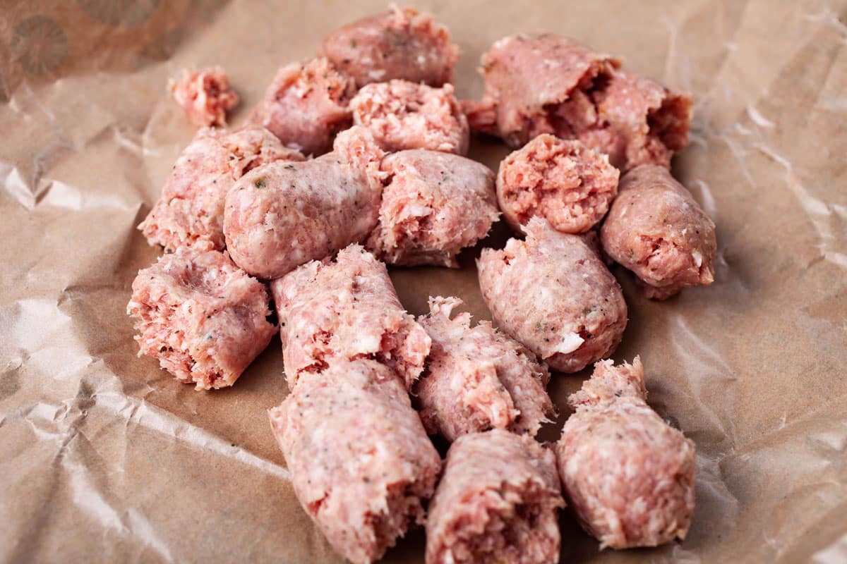 Chopped and skinned sausages resting on butcher paper.