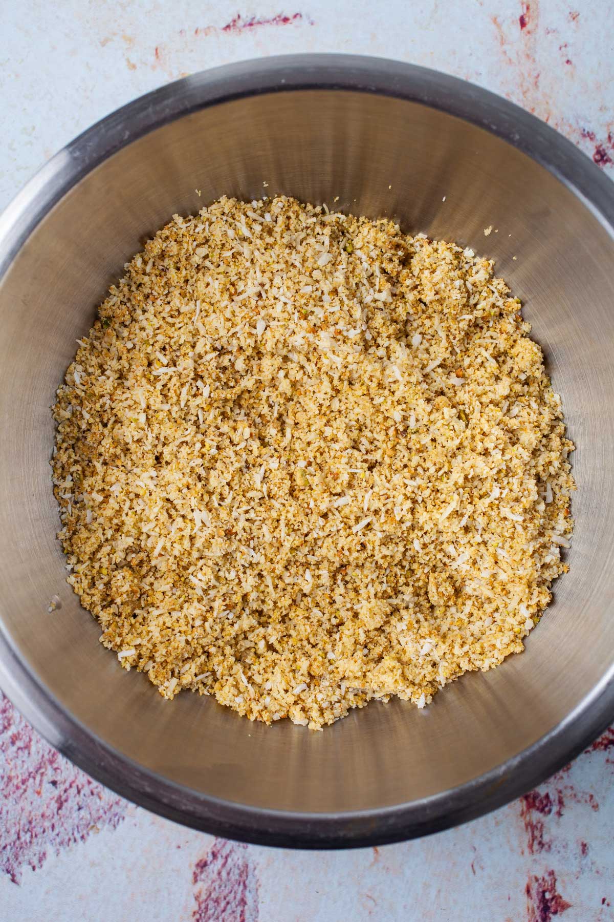 Coconut and pistachio meal in a stainless steel bowl.