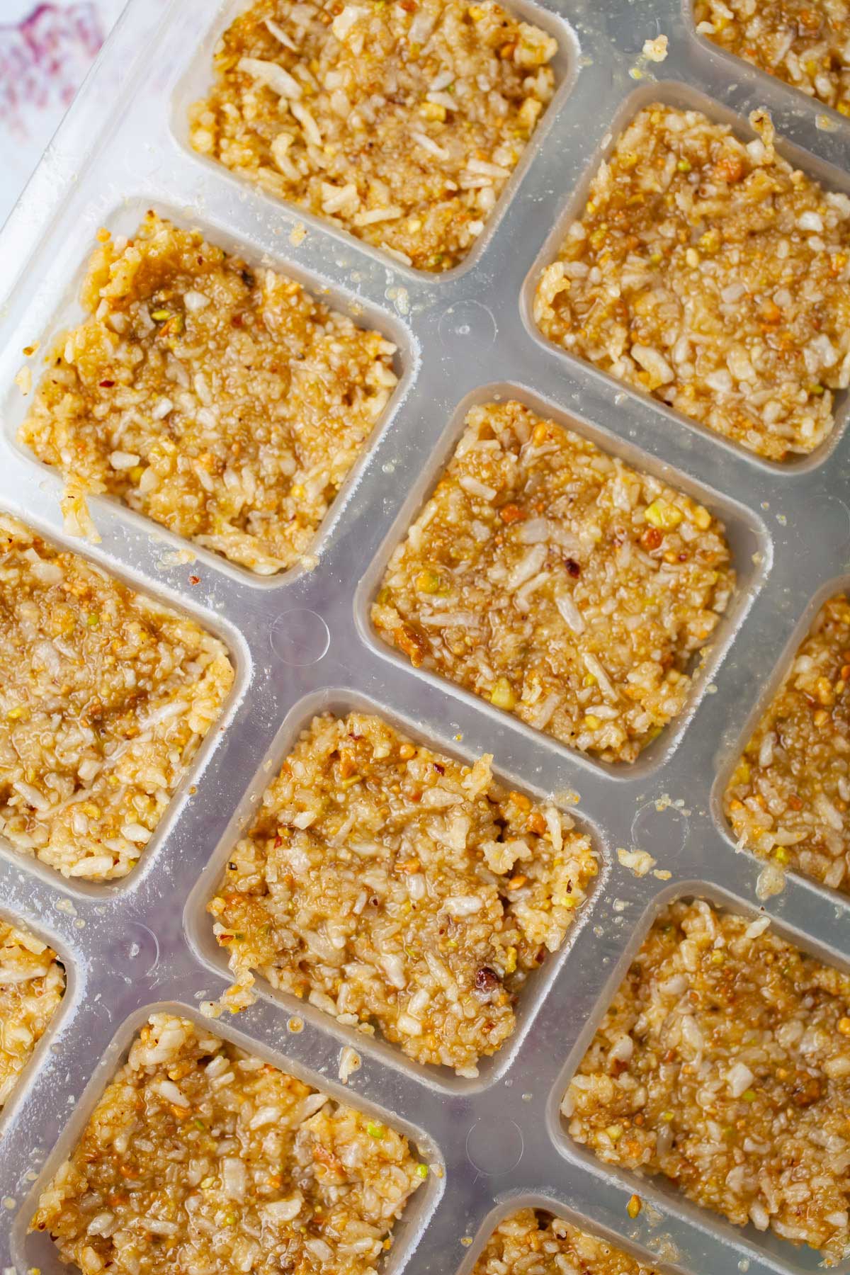 Coconut bites pressed into ice cube molds.