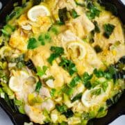 Creamy cooked cod and leek in a cast iron pan.