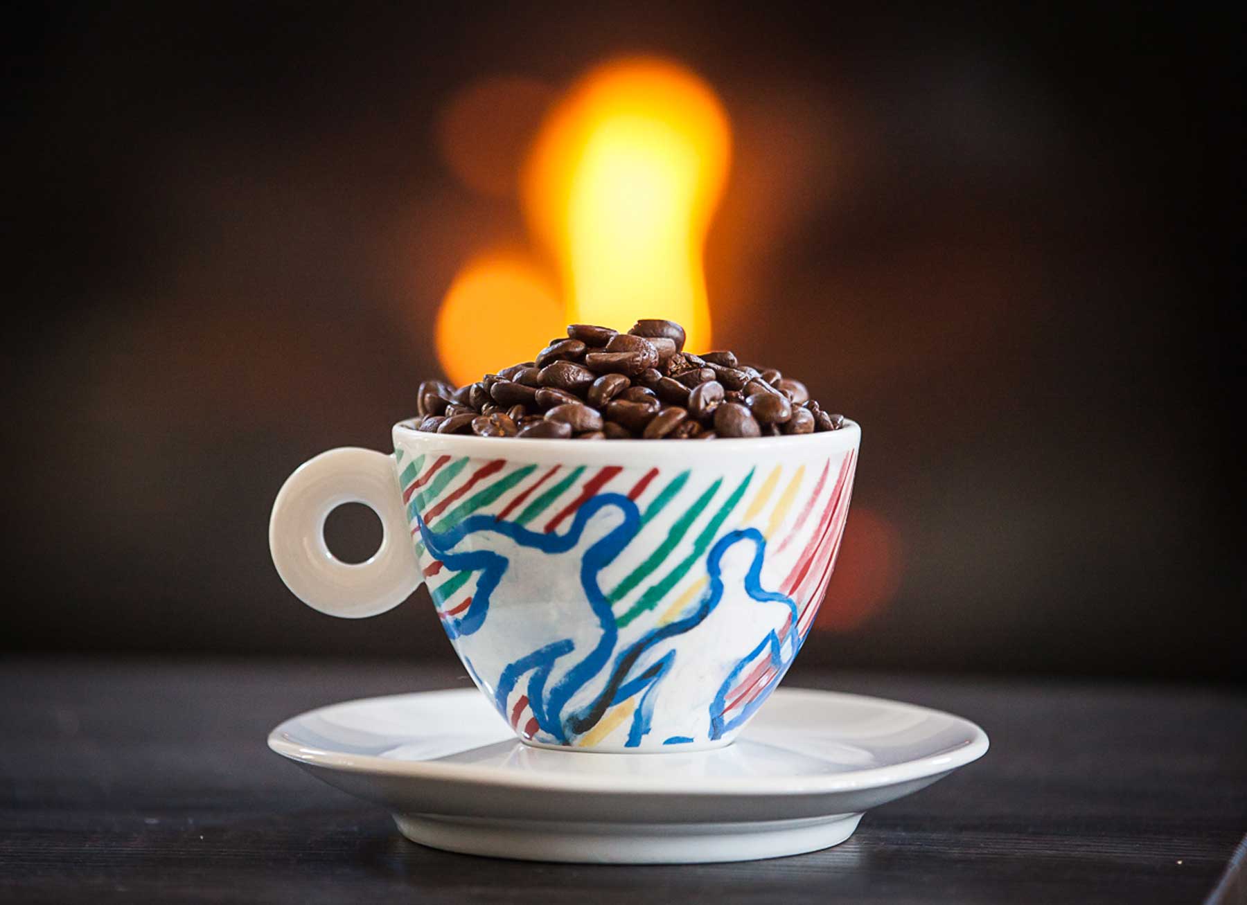 A coffee cup filled with whole coffee beans.