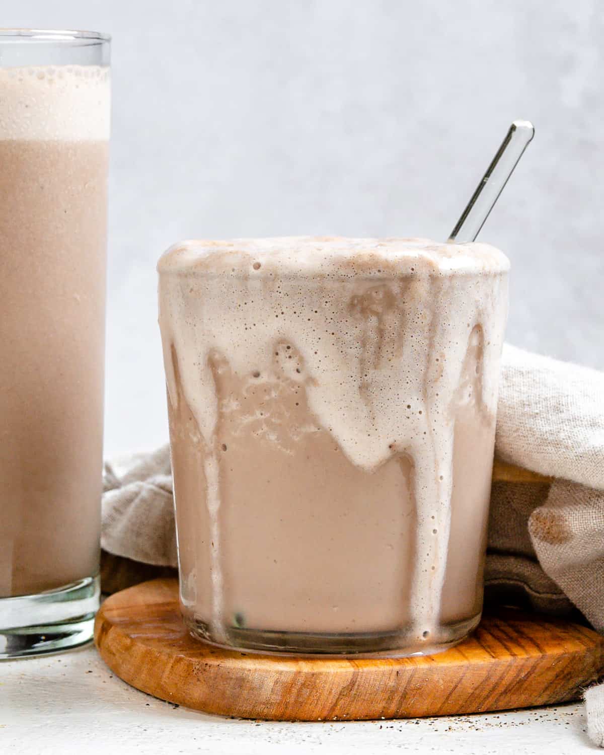 Overflowing coffee milkshake in a cup.