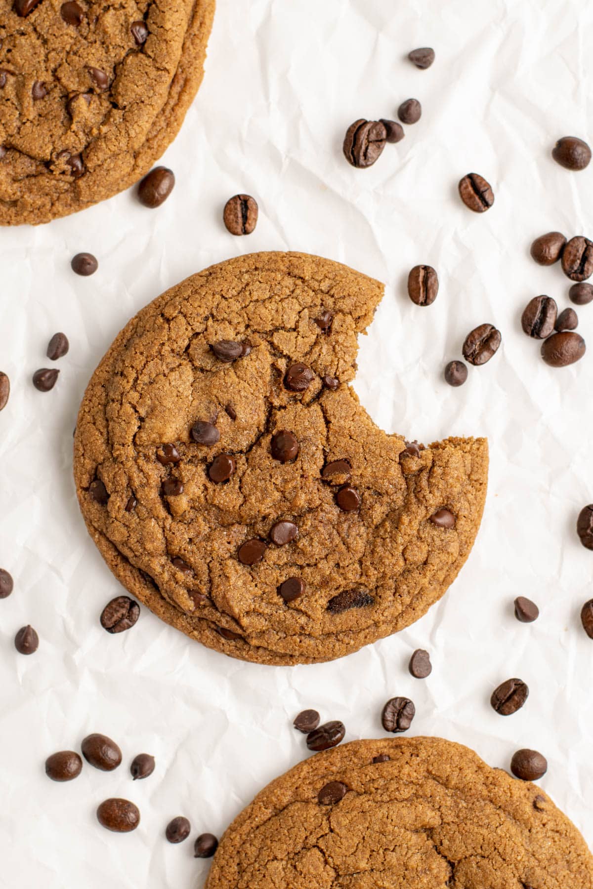 A bite taken out of a coffee cookie topped with chocolate chips.