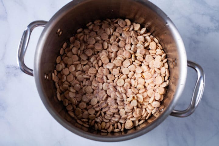  Une grande casserole remplie de haricots Lupini non cuits et garnie de sel.