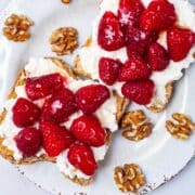 Two toasts on a plate with peanut butter, cottage cheese, fresh berries and a drizzle of honey.