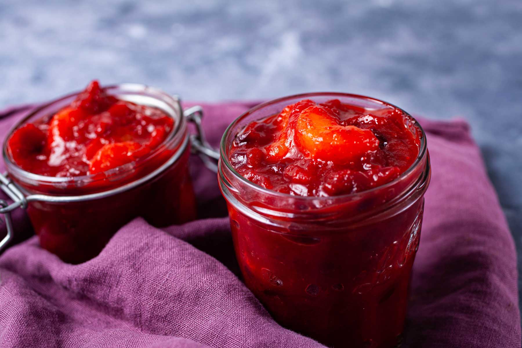 Mandarin orange cranberry sauce stored in glass containers.